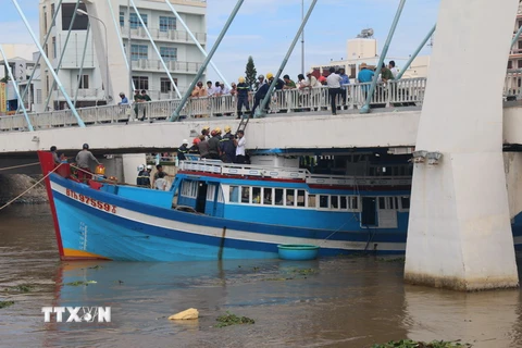 Các lực lượng chức năng đang khẩn trương cứu hộ tàu BTh 97559TS bị mắc kẹt dưới gầm cầu Lê Hồng Phong. (Ảnh: Hồng Hiếu/TTXVN)