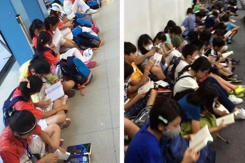 Học sinh Trung Quốc và học sinh Nhật Bản cùng ngồi đọc sách trong khi chờ đợi ở sân bay. (Nguồn: Weibo)