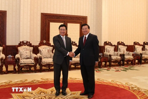 Thủ tướng Chính phủ Thongloun Sisoulith đón Phó Thủ tướng Phạm Bình Minh. (Ảnh: Phạm Kiên/TTXVN)