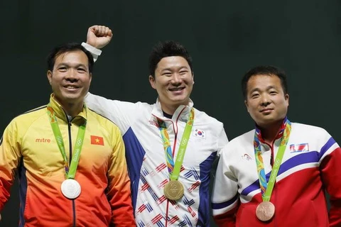 Xạ thủ Hoàng Xuân Vinh (trái) mang về tấm Huy chương thứ hai cho thể thao Việt Nam tại Olympic Rio ngày 10/8. Đứng giữa là nhà vô địch Jin Jong-oh và bên phải là vận động viên Kim Song Guk. EPA/ TTXVN