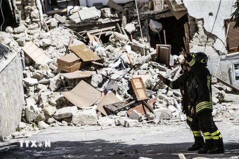 Lính cứu hỏa tham gia công tác cứu hộ tại hiện trường đổ nát sau động đất. (Nguồn: EPA/TTXVN)