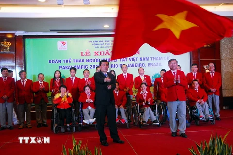 Bộ trưởng Bộ Văn hóa, Thể thao và Du lịch Nguyễn Ngọc Thiện trao cờ cho Đoàn thể thao người khuyết tật Việt Nam tham dự Paralympic 2016. (Ảnh: Mạnh Linh/TTXVN)
