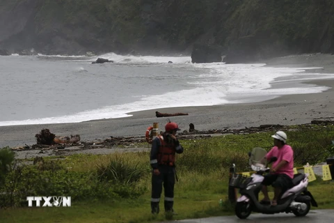 Lực lượng bảo vệ bờ biển (trái) khuyến cáo người dân không đến gần khu vực bờ biển trong bão Malakas tại Nghi Lan, Đài Loan ngày 17/9. (Nguồn: EPA/TTXVN)