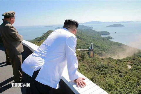 Nhà lãnh đạo Triều Tiên Kim Jong-un (phải) thị sát việc thử nghiệm trên mặt đất động cơ tên lửa công suất lớn tại Trung tâm vũ trụ Sohae, Triều Tiên. (Nguồn: Yonhap/TTXVN)