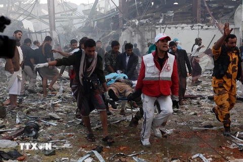 Chuyển thi thể nạn nhân khỏi hiện trường sau vụ không kích của liên quân xuống Sanaa ngày 8/10. (Nguồn: AFP/TTXVN)