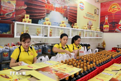 Đóng gói nước mắm cho khách du lịch tại doanh nghiệp sản xuất nước mắm Khải Hoàn (Phú Quốc). (Ảnh: Lê Huy Hải/TTXVN)