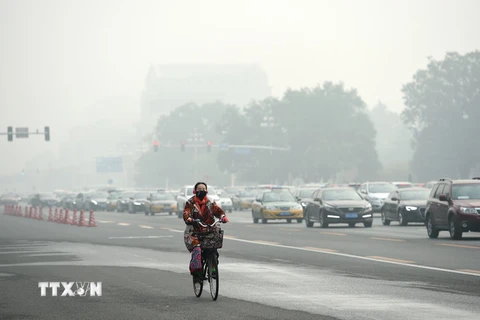 Người dân Trung Quốc đeo khẩu trang để tránh tác hại của khói mù ô nhiễm tại thủ đô Bắc Kinh, Trung Quốc ngày 14/10. (Nguồn: THX/TTXVN)