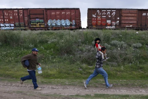 Người nhập cư chạy theo 1 chuyến tàu ở biên giới Mexico-Mỹ. (Nguồn: Reuters)