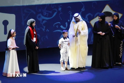 Quốc vương Dubai Sheikh Mohammed Bin Rashid Al-Maktoum (phải) trao giải thưởng trị giá 150.000 USD cho một em bé người Algieri 7 tuổi vừa đoạt giải trong cuộc thi nhân 'Năm đọc sách' với chủ đề 'Thử thách trong việc đọc tiếng Arab,' tại Dubai ngày 24/10. 