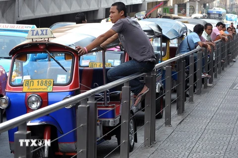Lái xe tuktuk Thái Lan đợi khách hàng tại trung tâm thương mại ở thủ đô B​angkok. (Nguồn: AFP/TTXVN)