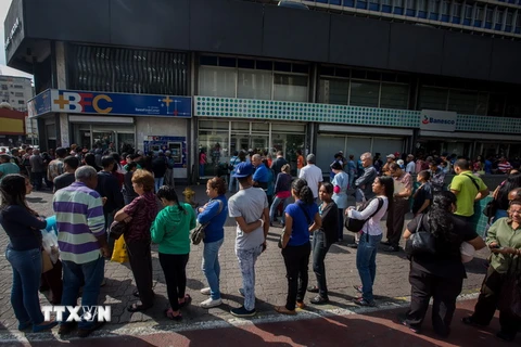 Người dân Venezuela xếp hàng chờ giao dịch bên ngoài Ngân hàng Trung ương ở Caracas ngày 17/12/2016. (Nguồn: EPA/TTXVN)