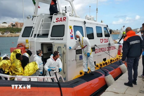 Tàu của Lực lượng bảo vệ bờ biển Italy đưa những người di cư tới đảo Lampedusa , Italy. (Nguồn: EPA/TTXVN)