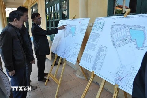 Người dân xã Phù Đổng, Trung Mầu (huyện Gia Lâm) xem bản quy hoạch nhà máy nước mặt sông Đuống. (Ảnh: Mạnh Khánh/TTXVN)