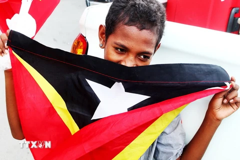 Một cậu bé với lá cờ Timor Leste trên đường phố. (Ảnh: Lâm Khánh/TTXVN)