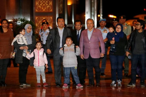 Ngoại trưởng Malaysia Anifah Aman (thứ 3 bên phải) cũng có mặt để chào đón công dân trở về. (Nguồn: Reuters) 