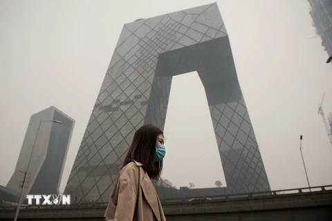 Người dân Trung Quốc đeo khẩu trang do ô nhiễm không khí ở Bắc Kinh ngày 20/3. (Nguồn: AFP/TTXVN)
