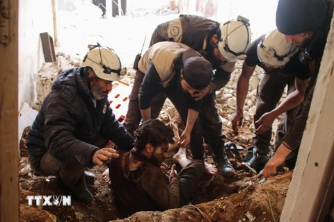 Giúp đỡ một nạn nhân bị thương trong cuộc không kích ở Daraa, Syria, ngày 8/4. (Nguồn: AFP/TTXVN)