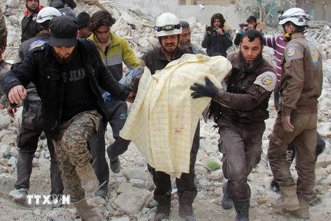 Lực lượng dân phòng Syria chuyển nạn nhân khỏi đống đổ nát sau một đợt không kích ở tỉnh Idlib ngày 15/2. (Nguồn: AFP/TTXVN)