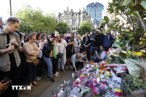 Người dân đặt hoa và thắp nến tại lễ tưởng niệm các nạn nhân vụ tấn công khủng bố ở Manchester. (Nguồn: THX/TTXVN)