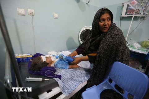 Điều trị cho người bị thương trong vụ nổ bom tại bệnh viện ở Harat ngày 26/5. (Nguồn: THX/TTXVN)