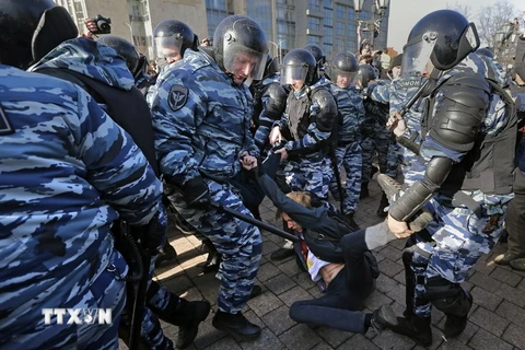 Cảnh sát chống bạo động Nga bắt giữ một người biểu tình trái phép ở Moskva ngày 26/3. (Nguồn: EPA/TTXVN)
