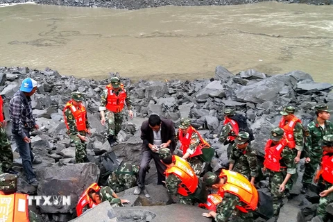 Các nhân viên cứu hộ làm nhiệm vụ tại hiện trường vụ lở đất. (Nguồn: EPA/TTXVN)