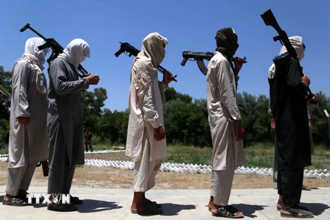 Các tay súng Taliban tại lễ giao nộp vũ khí đầu hàng Chính phủ ở Jalalabad, Afghanistan ngày 22/6. (Nguồn: EPA/TTXVN)