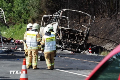 Lực lượng cứu hỏa làm nhiệm vụ tại hiện trường vụ tai nạn. (Nguồn: AFP/TTXVN)