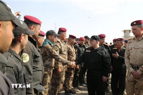 Thủ tướng Iraq Haider al-Abadi (phải, phía trước) chúc mừng các sỹ quan chỉ huy tại Mosul sau khi thành phố cổ được giải phóng hoàn toàn khỏi IS ngày 9/7. (Nguồn: THX/TTXVN)