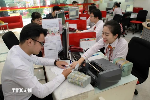 Khách hàng giao dịch tại Ngân hàng thương mại cổ phần Phát triển Nhà Thành phố Hồ Chí Minh (HDBank). (Ảnh: Trần Việt/TTXVN)