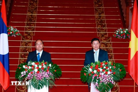Thủ tướng Nguyễn Xuân Phúc và Thủ tướng Lào Thongloun Sisoulith. (Ảnh: Thống Nhất/TTXVN)