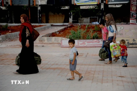 Người dân sơ tán khỏi khu vực xung đột Raqqa tới Aleppo, Syria ngày 27/7. (Nguồn: THX/TTXVN)