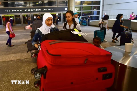 Hành khách tại Sân bay Quốc tế Los Angeles, Mỹ ngày 29/6. AFP/TTXVN