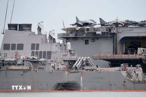 Một bên thân Tàu USS John S. McCain bị hư hỏng sau vụ va chạm với tàu chở dầu ở vùng biển ngoài khơi Singapore được lai dắt về căn cứ hải quân Changi ở Singapore ngày 22/8. (Nguồn: AFP/ TTXVN)