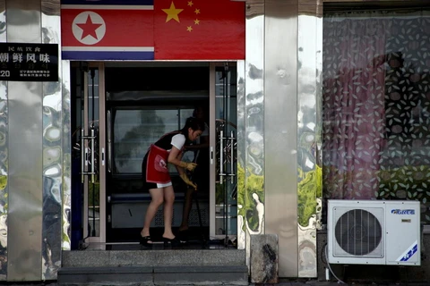 Một nhân viên phục vụ dọn dẹp trong một nhà hàng Triều Tiên ở Đan Đông. (Nguồn: Reuters)