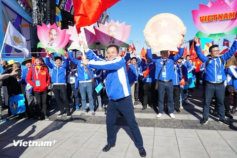 Anh Giàng Quốc Hưng, Bí thư Tỉnh đoàn Lào Cai, mang cờ Tổ quốc tham gia diễu hành cũng với đoàn đại biểu Việt Nam tại Festival. (Ảnh: Hằng Lê/Vietnam+)
