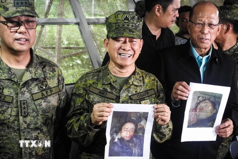 Bộ trưởng Quốc phòng Philippines Delfin Lorenzana (phải) và Chỉ huy trưởng quân đội Philippines Eduardo Ano (giữa) bên ảnh hai thủ lĩnh phiến quân Abu Sayyaf Isnilon Hapilon và Omarkhayam Maute tại cuộc họp báo ở Mindanao ngày 16/10. (Nguồn: AFP/TTXVN)