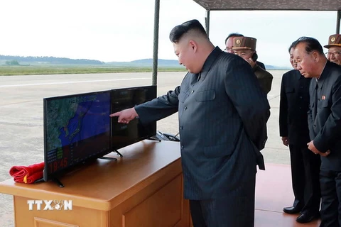 Nhà lãnh đạo Kim Jong-un (trái) thị sát vụ phóng thử tên lửa Hwasong-12 tại một địa điểm bí mật. (Nguồn: AFP/TTXVN)