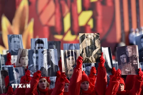 Người dân Nga tham gia diễu hành tại một lễ kỷ niệm Cách mạng tháng 10 ở Moskva. (Nguồn: AFP/TTXVN)