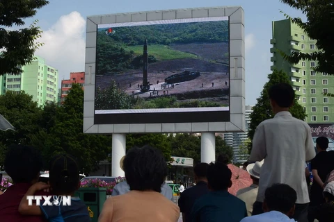 Người dân Triều Tiên theo dõi tin tức về vụ phóng tên lửa đạn đạo liên lục địa Hwasong-14 trên màn hình lớn gần một nhà ga xe lửa ở Bình Nhưỡng ngày 4/7. (Nguồn: AFP/TTXVN)