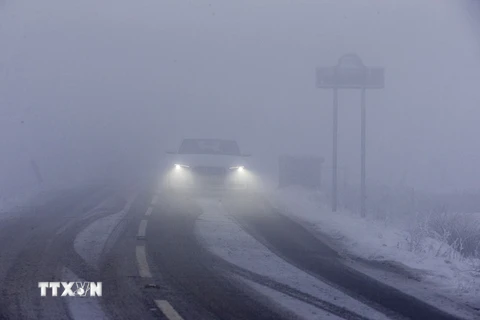 Ôtô di chuyển trên đường trong tuyết và sương mù dày đặc tại Derbyshire, miền Bắc Anh. (Nguồn: AFP/TTXVN) 