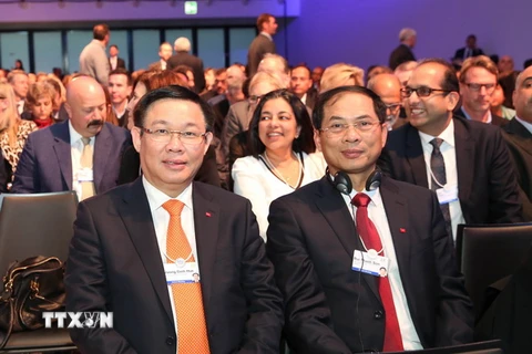 Phó Thủ tướng Vương Đình Huệ (bên trái) và Thứ trưởng Thường trực Bộ Ngoại giao Bùi Thanh Sơn dự phiên khai mạc toàn thể Hội nghị thường niên lần thứ 48 Diễn đàn Kinh tế Thế giới. (Ảnh: Hoàng Hoa/TTXVN)