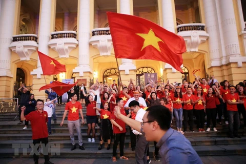 Cổ động viên tại khu vực Nhà hát Lớn Hà Nội ăn mừng khi đội tuyển Việt Nam thắng lượt đá luân lưu trong trận đấu với U23 Qatar. (Nguồn: TTXVN) 