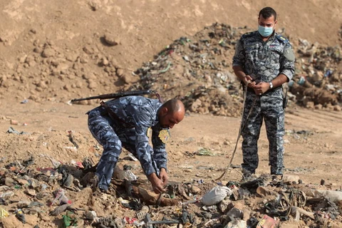 Cảnh sát Iraq khai quật thi thể được tìm thấy trong một ngôi mộ tập thể ở Hamam al-Alil trong chiến dịch giải phóng Mosul ngày 7/11/2017. (Nguồn: AFP/TTXVN)