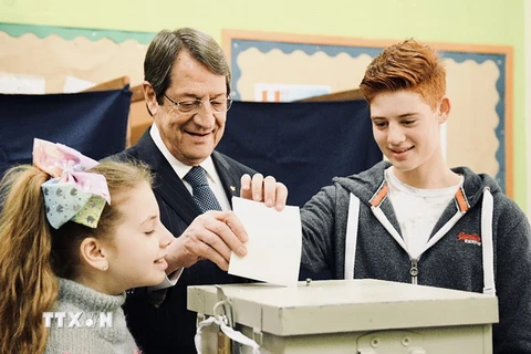 Tổng thống Cyprus Nicos Anastasiades (giữa) bỏ phiếu tại một điểm bầu cử ở Limassol ngày 28/1. (Nguồn: THX/TTXVN)