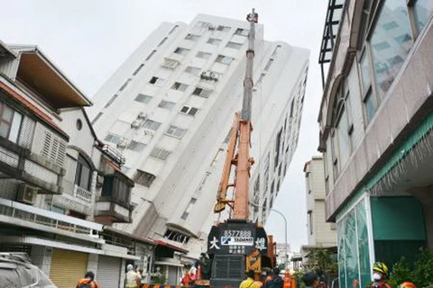 Lực lượng cứu hộ làm nhiệm vụ tại khu vực một tòa nhà bị đổ nghiêng sau trận động đất ở Đài Loan, Trung Quốc ngày 7/2. (Nguồn: Kyodo/TTXVN) 