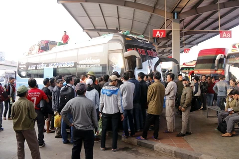 Rất đông người Việt đến bến xe ở Thủ đô Vientiane (Lào) để về quê ăn Tết. (Ảnh: Phạm Kiên/TTXVN)