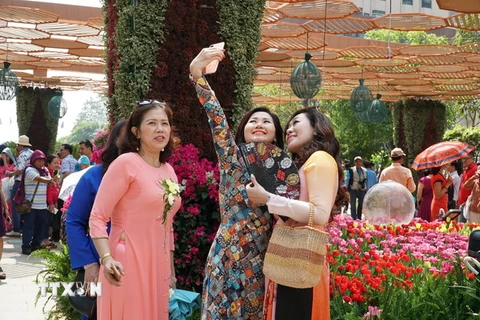 Người dân Thành phố Hồ Chí Minh du Xuân và chụp ảnh lưu niệm tại đường hoa Nguyễn Huệ. (Ảnh: Phương Vy/TTXVN)