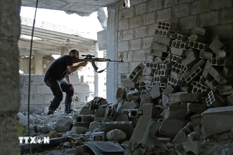 Một tay súng thuộc lượng đối lập Syria nã súng tại Ain Tarma, Đông Ghouta. (Nguồn: AFP/TTXVN)