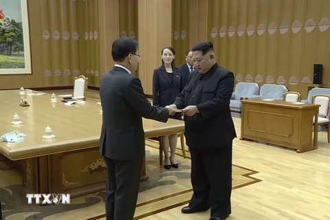 Nhà lãnh đạo Triều Tiên Kim Jong-un (phải) nhận thư của Tổng thống Hàn Quốc Moon Jae-in được ông Chung Eui-yong (trái) chuyển tới Bình Nhưỡng ngày 5/3. (Nguồn: YONHAP/TTXVN)